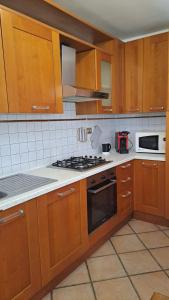 La cuisine est équipée de placards en bois et d'un four avec plaques de cuisson. dans l'établissement La casa nel borgo, à Bracciano