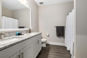 a white bathroom with a sink and a toilet at Modern 2BR 2BA New Build Condo with Garage & Patio in Wyoming +32 photos