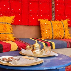 una mesa con un hervidor de agua y platos de comida. en Riad Hassi Labied Merzouga en Merzouga