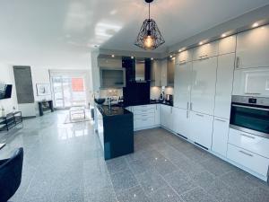 博恩海姆的住宿－my exclusive home，厨房配有白色橱柜和黑色台面