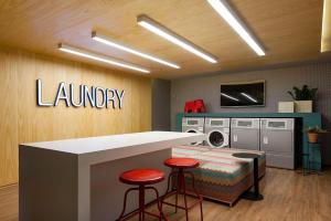 a laundry room with a counter and two stools at Studio Alpha Stay One in Barueri