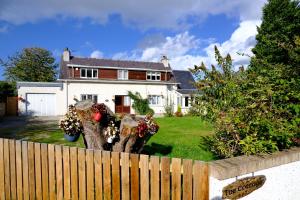 a white house with a fence in front of a yard at Lovely 1-bedroom apartment with free parking in Inverness