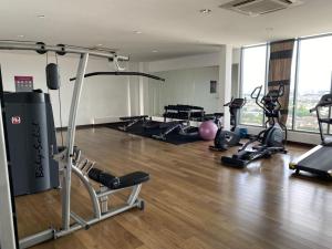 einen Fitnessraum mit mehreren Laufbändern und Maschinen in einem Zimmer in der Unterkunft Damen Suite (A) Sunway Subang by DW in Subang Jaya