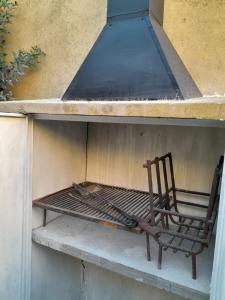 a chair sitting on a bench under a stove at chalet de tata in Tandil