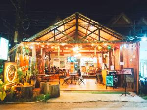 a building with lights on it with tables and chairs at Khao-Sok Bed and Breakfast in Khao Sok National Park