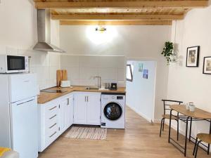 a kitchen with a washing machine and a table at Casa Saboa in San Bartolomé