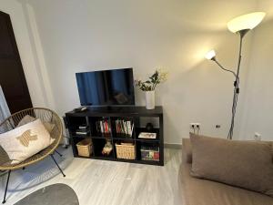 a living room with a flat screen tv on a shelf at Casa de Eugenia in Málaga