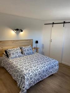 a bedroom with a bed with a blue and white comforter at Casa Saboa in San Bartolomé
