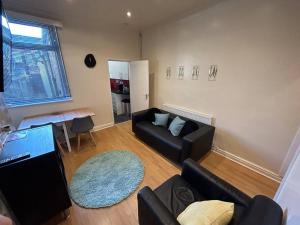 uma sala de estar com um sofá e uma mesa em Practical and Spacious Property em Stoke-on-Trent