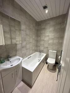 a bathroom with a sink and a tub and a toilet at Practical and Spacious Property in Stoke on Trent