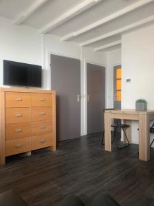 een kamer met een bureau en een dressoir met een televisie bij Het molenhuisje in Winsum