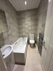 y baño con bañera, lavabo y aseo. en Practical and Spacious Property, en Stoke on Trent