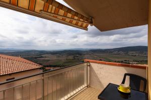 a balcony with a table and a hat on it at Mansarda vista mare in Massa Marittima