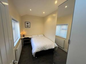 a small bedroom with a bed and a desk in it at Practical and Spacious Property in Stoke on Trent