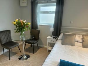 Un dormitorio con una cama y una mesa con un jarrón de flores. en 29a, en Downham Market