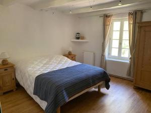 Un dormitorio con una cama con una manta azul. en Montjoïa Le gîte bleu, en Le Thor