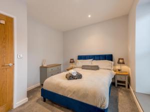 シュルーズベリーにあるPass the Keys 5B One bedrom Central Modern Apartmentのベッドルーム1室(青いベッド1台、ナイトスタンド2台付)