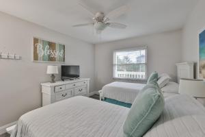 1 Schlafzimmer mit 2 Betten und einem Deckenventilator in der Unterkunft 100 steps to beautiful Indian Rocks Beach, oceanside, 2 bedroom updated condo in Clearwater Beach