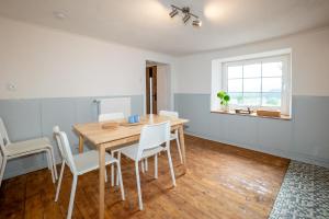 a dining room with a wooden table and white chairs at Ferienhaus Schneifel in Auw +36 photos