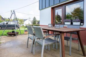a wooden table and chairs on a patio at Ferienhaus Schneifel in Auw