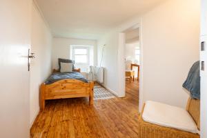 a bedroom with a bed and a wooden floor at Ferienhaus Schneifel in Auw