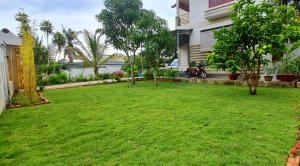 un patio con césped verde frente a una casa en Peaceful Villa Seaview - From The Beach 400m en Phan Thiet