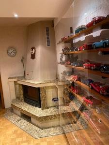 Una chimenea en una habitación con coches de juguete en estanterías en Eda Aparts, en Devin