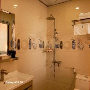 y baño con ducha y lavamanos. en Volga Hotel en Vung Tau