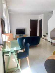 sala de estar con mesa y sofá azul en Casa Belvedere Mediterrean, en Rovio