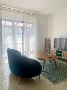 Sala de estar con sofá azul y mesa de centro en Casa Belvedere Mediterrean, en Rovio