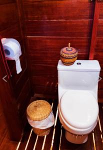 a bathroom with a toilet in a wooden wall at Tambopata Edosikiana Lodge in Tambopata
