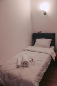 Una cama blanca con toallas encima. en Apple cozy hotel en Tiflis