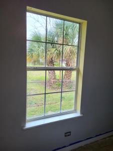 ein Fenster mit Blick auf eine Palme in der Unterkunft Old Biloxi Rest, Relax and Enjoy the Beach in Biloxi