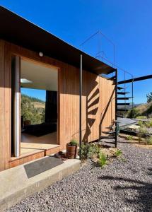 a house with a large glass window and a staircase at Casa en la Vega de pupuya in Navidad