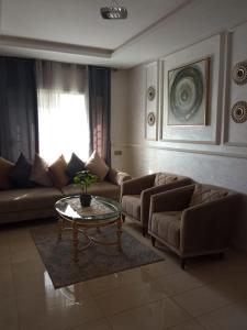 a living room with two couches and a coffee table at Chambre haut standing in Rabat