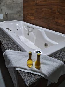 two bottles of beer sitting on a towel next to a bath tub at Hotel Reserva do Xingó in Piranhas