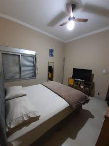 a bedroom with a bed and a ceiling fan at Casa Localizado no Centro de Guape MG in Guapé
