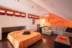 een slaapkamer met een bed en een bank in een kamer bij Mansarda vista mare in Massa Marittima