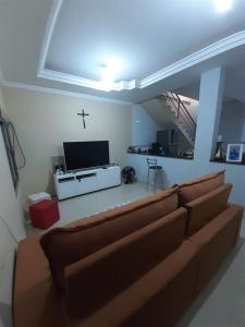 a living room with a couch and a cross on the wall at Casa Localizado no Centro de Guape MG in Guapé