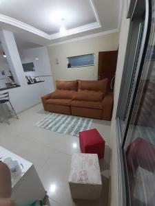 uma sala de estar com um sofá castanho e uma caixa vermelha em Casa Localizado no Centro de Guape MG em Guapé