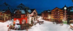 アーク 1950にあるArc 1950 Appartement skis aux piedsの雪の中に時計塔と建物がある町