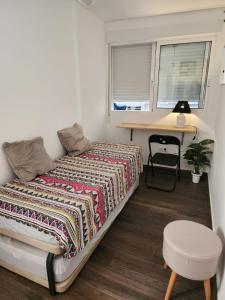 1 dormitorio con cama, escritorio y mesa en Anna's apartments, en Alicante