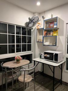 uma pequena cozinha com uma mesa e um micro-ondas em Comfy Crib Hostel em Bangkok