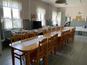 uma grande sala de jantar com uma mesa longa e cadeiras em Opintola Bed & Breakfast em Norinkylä