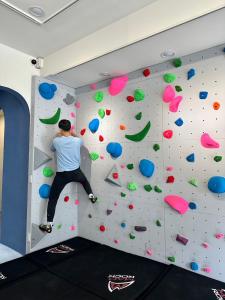 a man is on a climbing wall in a gym at Heyyo Hostel in Hualien City
