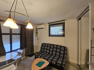 ein Wohnzimmer mit einem Sofa und einem Tisch in der Unterkunft Studio bien équipé proche mer in Montpellier