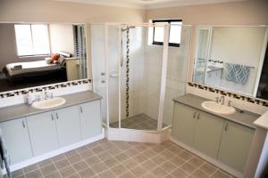 a bathroom with two sinks and a shower at Madora Bay Beach House in Mandurah