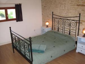 una camera da letto con un letto con un piumone verde di Le Noisetier at Les Hiboux Gites a Chef-Boutonne Altre 17 foto