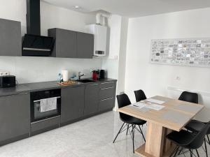 a kitchen with a wooden table and black cabinets at Apartment NUMBER 17 in Vienna