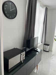 a living room with a tv and a clock on a wall at Apartment NUMBER 17 in Vienna